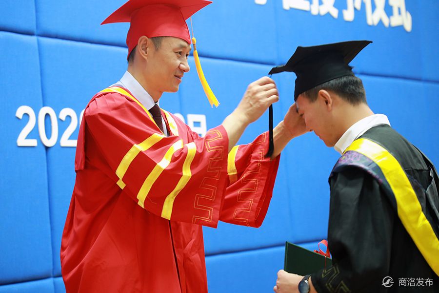 校领导刘勇,彭虎军分别为现场200名获了学士学位的毕业生拨穗正冠